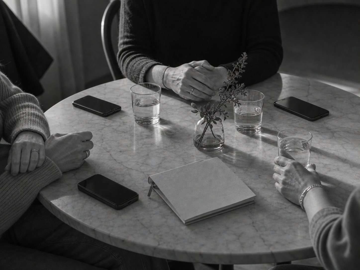 Mesa pequena com telefones pousados e copos, representando presença real para além dos grupos digitais