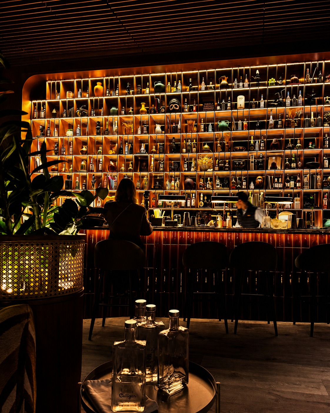 Bar iluminado do Bugio, em Oeiras, com garrafas, luz quente e ambiente intimista