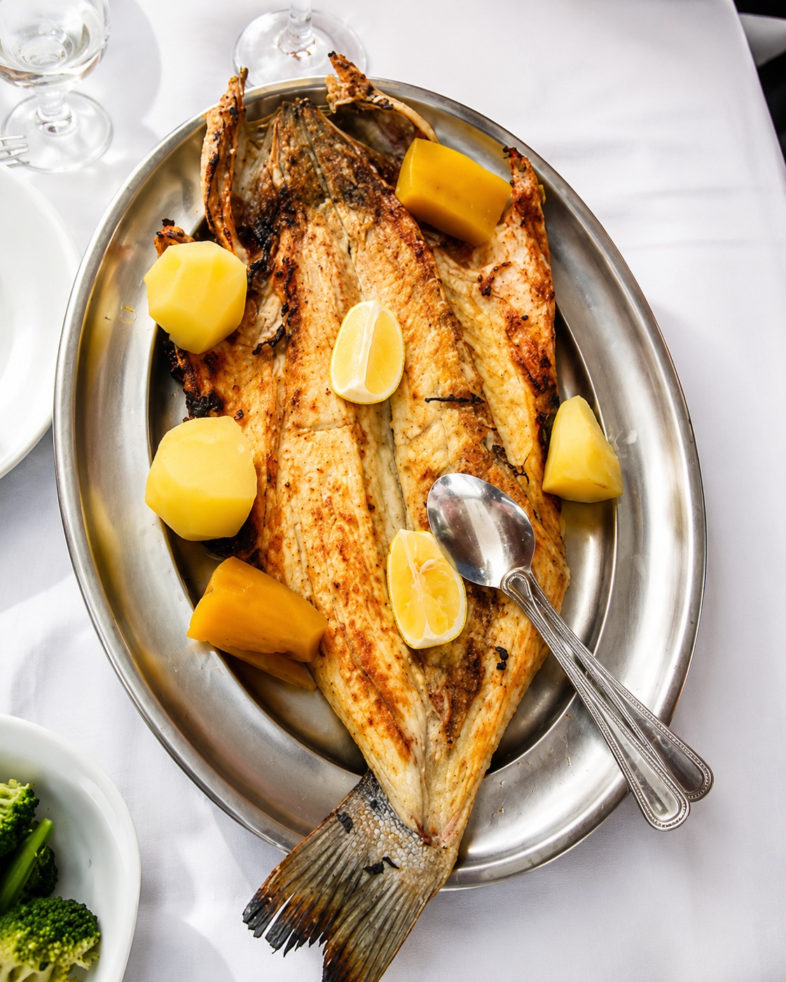 Peixe grelhado servido numa travessa no Quitanda Centro Náutico, em Paço de Arcos